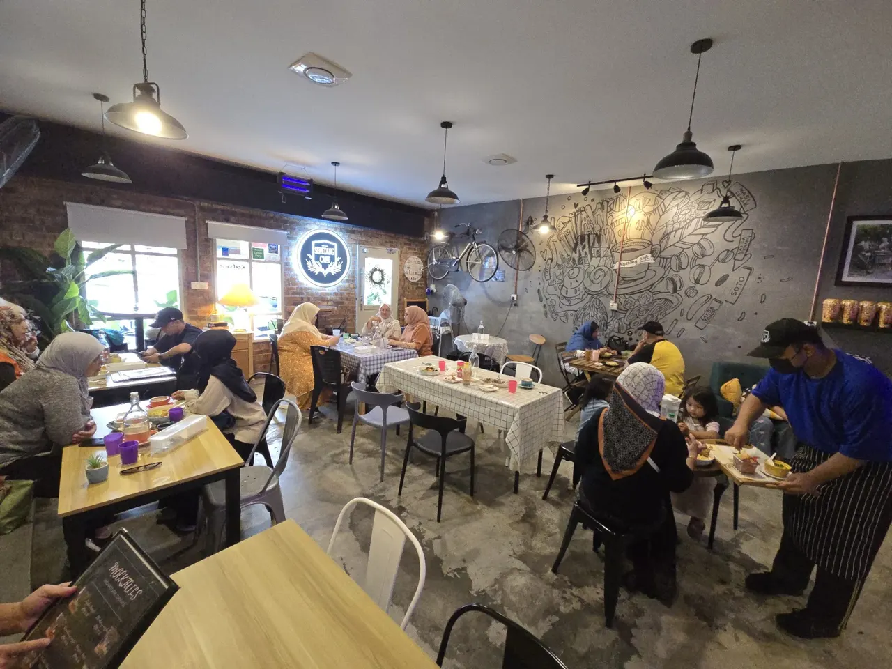 Guests dining at Sepetang Cafe's industrial-style dining room