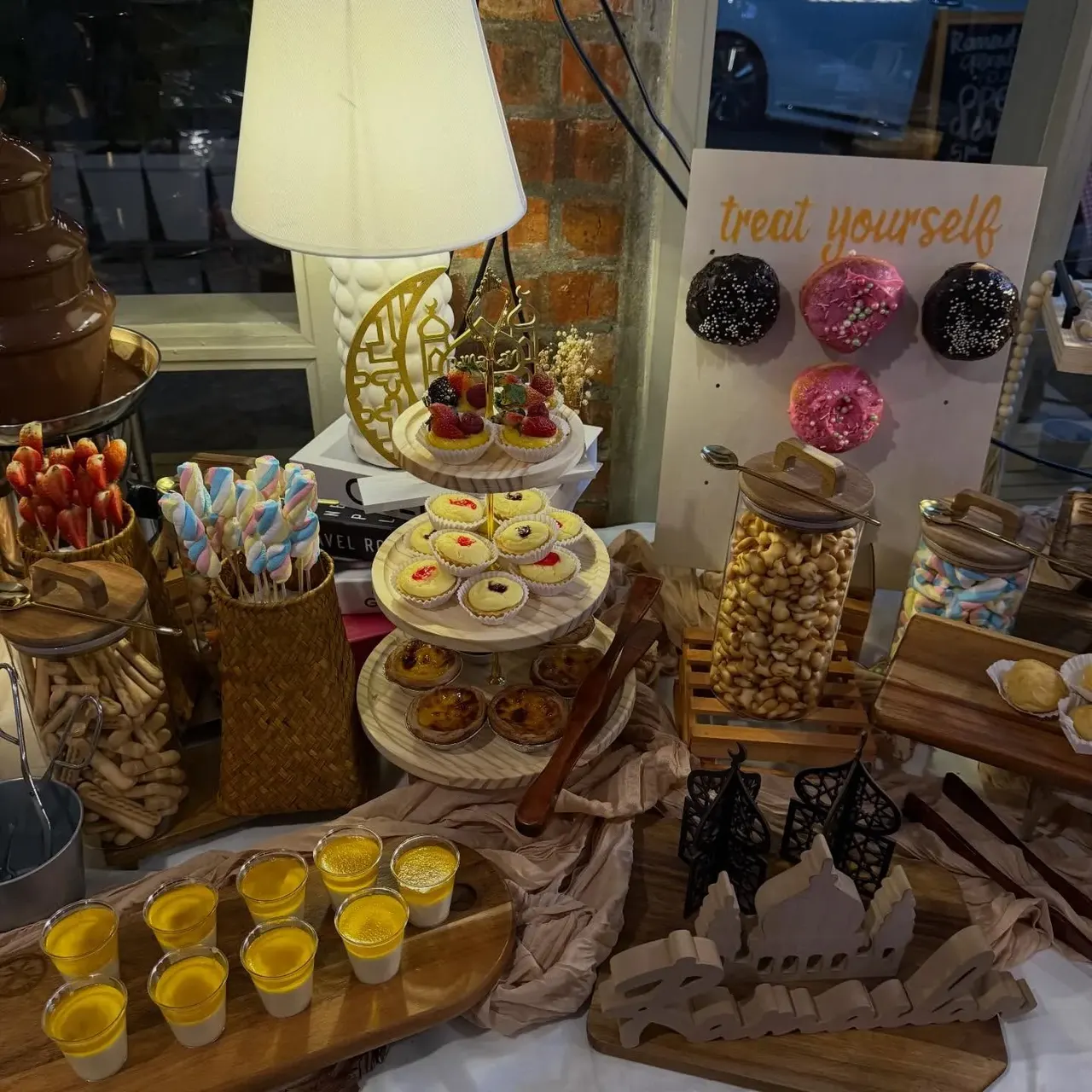 Dessert bar with tiered tarts and a donut wall